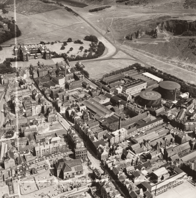Aerial view of the Canongate area c. 1951 including Holyrood Palace, the Meadow Flat Gas Holders (now the site of Dynamic Earth) and Holyrood Brewery (now the site of the Scottish Parliament).: (c) Historic Environment Scotland