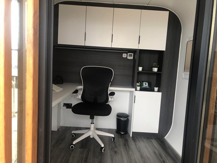 This image shows the inside of a WorkfromHub remote office with a desk and chair