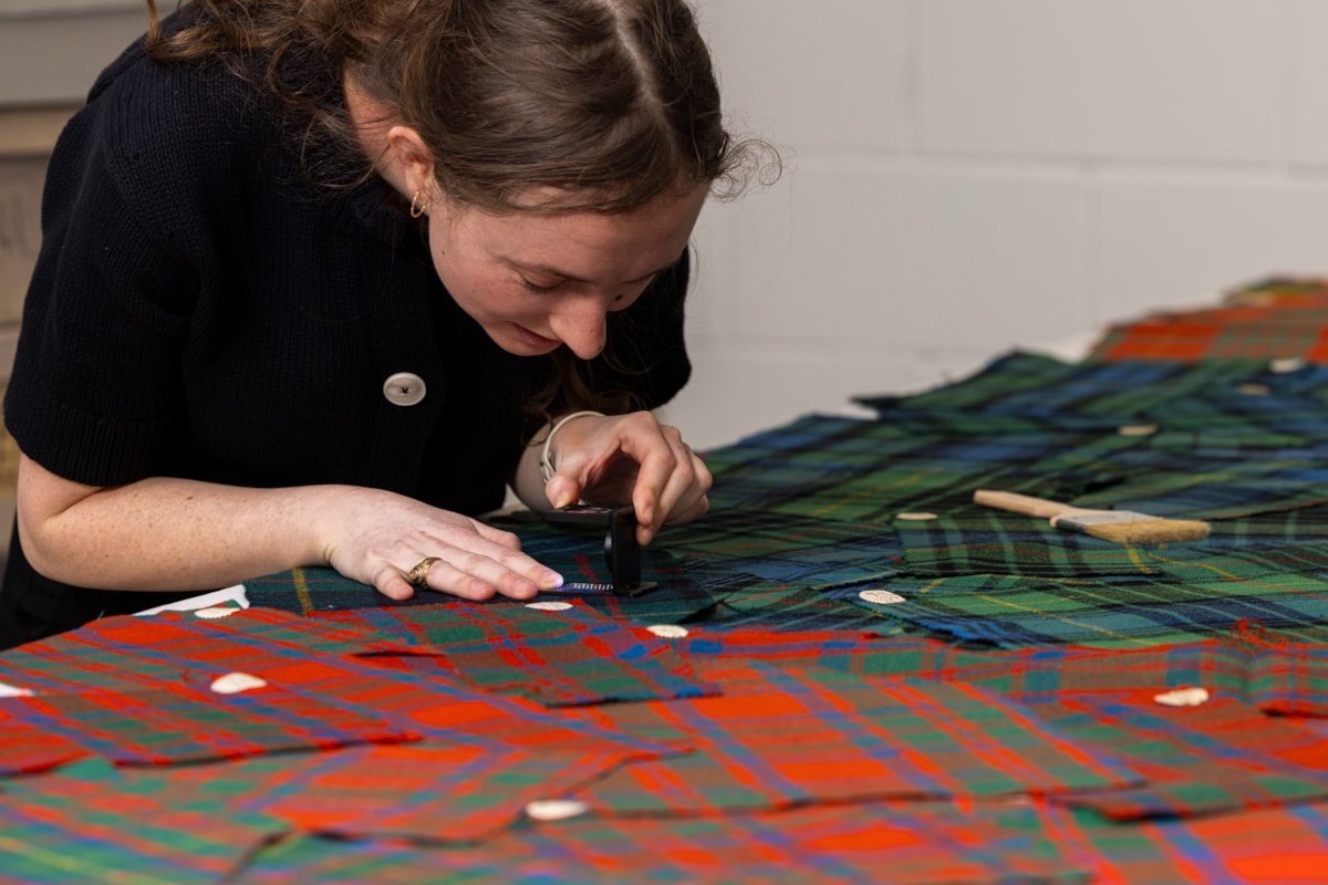 A University of Glasgow students examines the tartan samples. Photo © Duncan McGlynn (3)