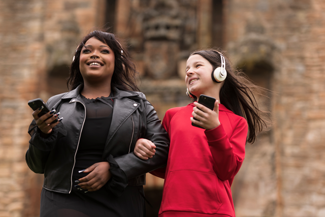 Linlithgow Scots Audio Guide: Laura Lovemore, a professional Scottish actor who provides the voice of Margaret More, one of the women known in the records as the ‘Moorish Lassies’, listening to the new Scots audio guide at Linlithgow Palace with Martha who voices the young Princess Elizabeth, daughter of James VI & Anna of Denmark.