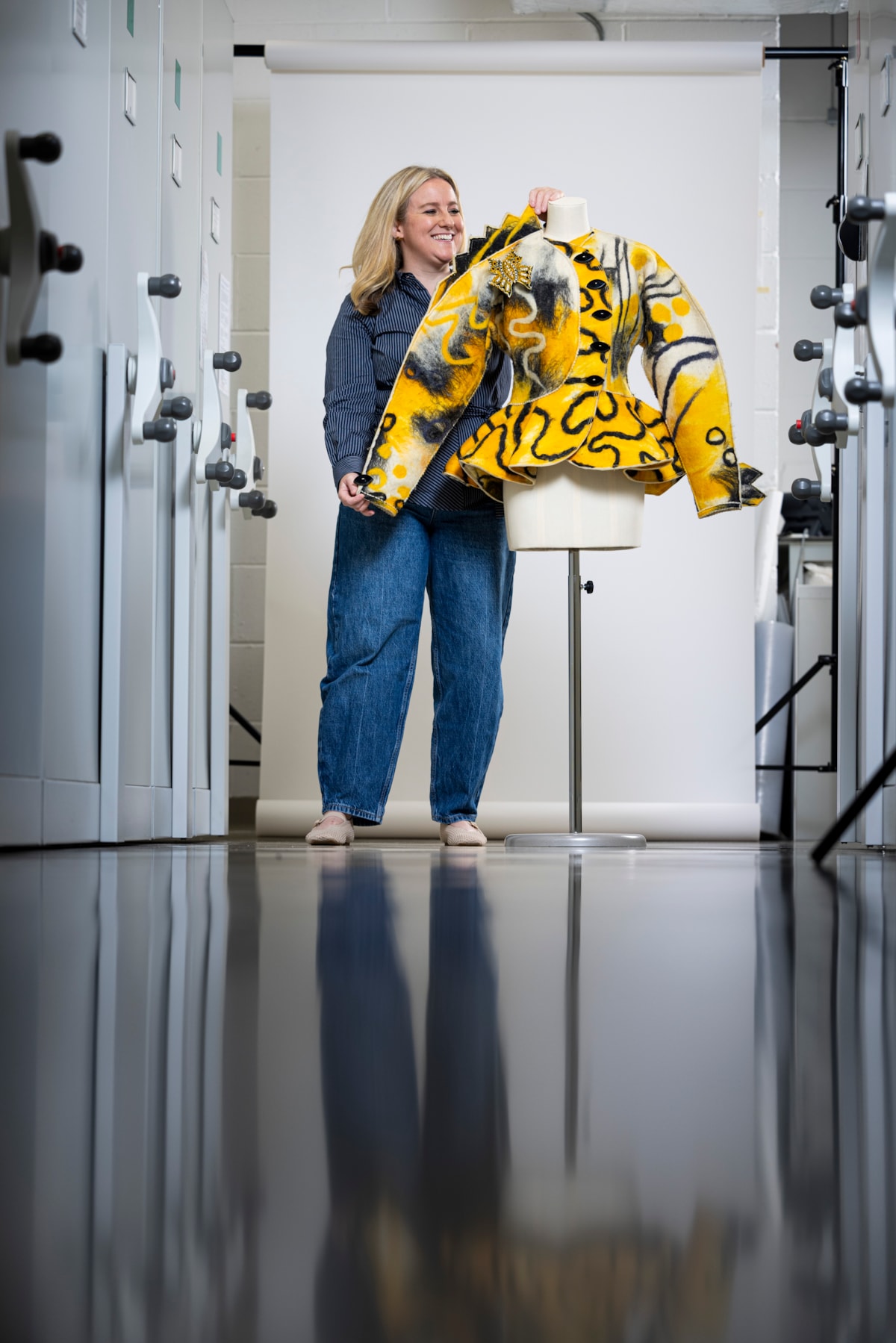 Curator Lisa Mason examines a yellow jacked designed by Jean Muir. Photo © Duncan McGlynn (6)