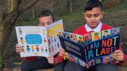 Year 6 pupils Manny (left) and Ayush reading in the forest school at Howick Church of England Primary School