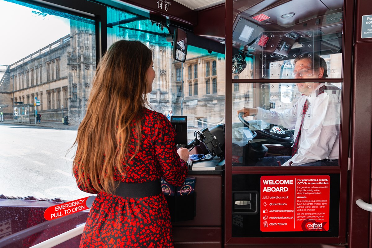 A passenger boarding an Oxford Bus Company bus