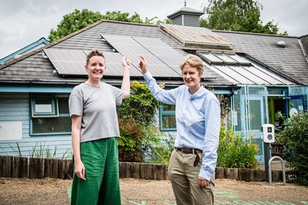 Jo Corrall (left) and Cllr Champion (right) point to the new solar panels at the Islington Ecology Centre