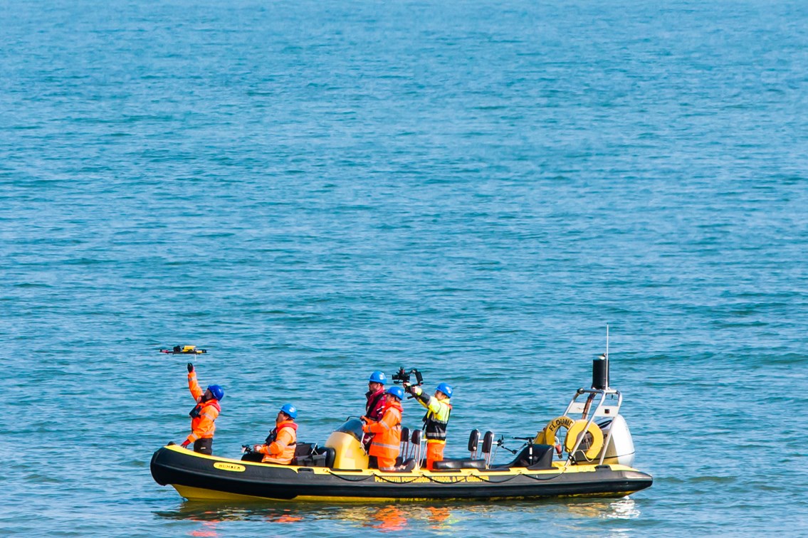 Crew in RIB with UAV 6: Unmanned Aerial Vehicle (UAV) being launched from a Rigid Inflatable Boat (RIB) at Teignmouth as part of a geological survey to improve the resilience of the railway between Exeter and Newton Abbot