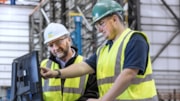 Credit ORE Catapult: TIGGOR Supply Chain Programme: Two male workers, in high vis vests, hard hats & safety glasses are looking at a laptop computer. ORE Catapult TIGGOR Supply Chain Programme