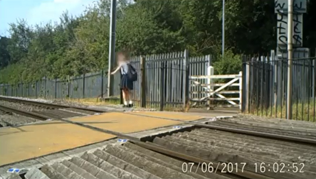 Young girl balancing on rail at Cotton Lane level crossing in St Albans