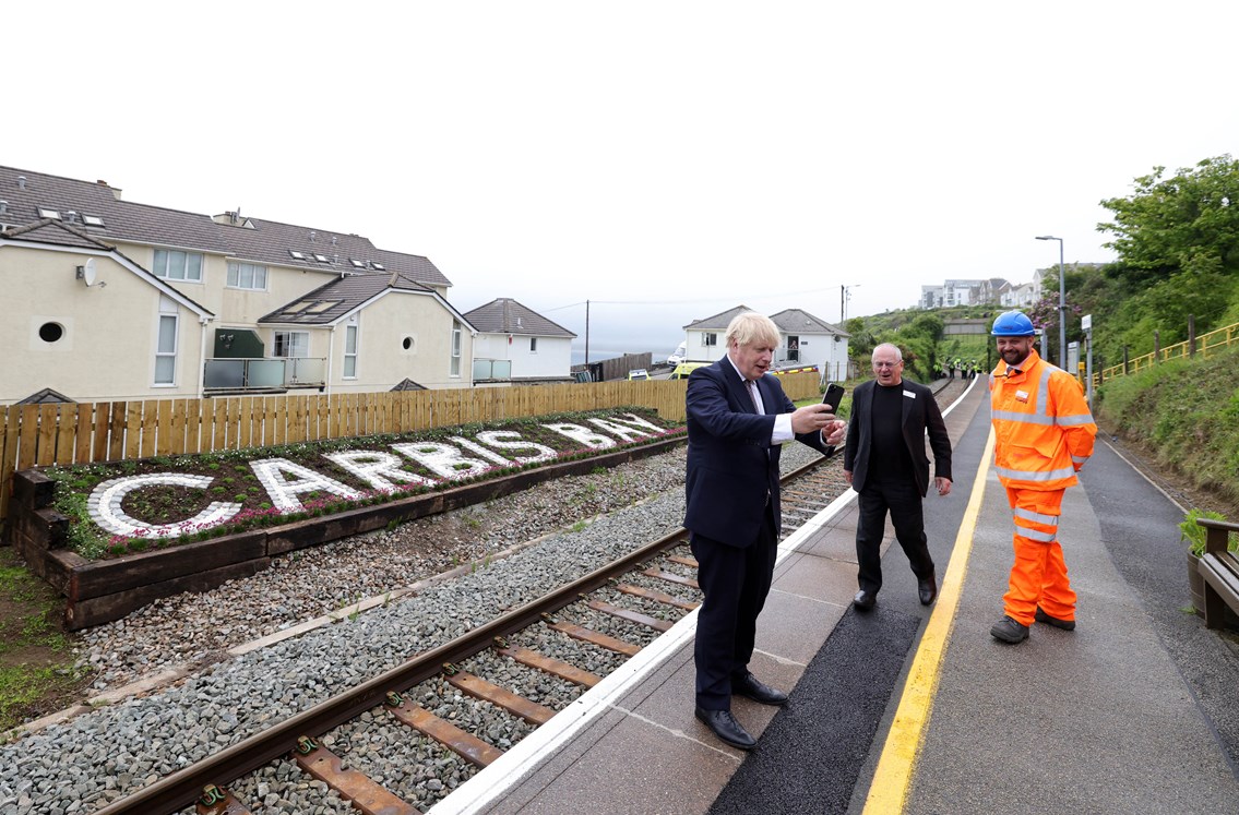Prime Minister, Boris Johnson, takes a selfie in front of the new station sign at Carbis Bay.