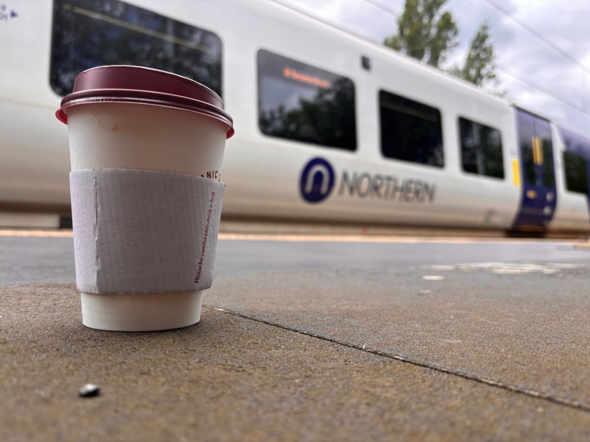 Image shows coffee cup alongside Northern train