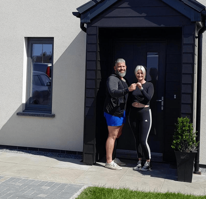 Couple standing outside their new council house Ricky and Jodie Wharton