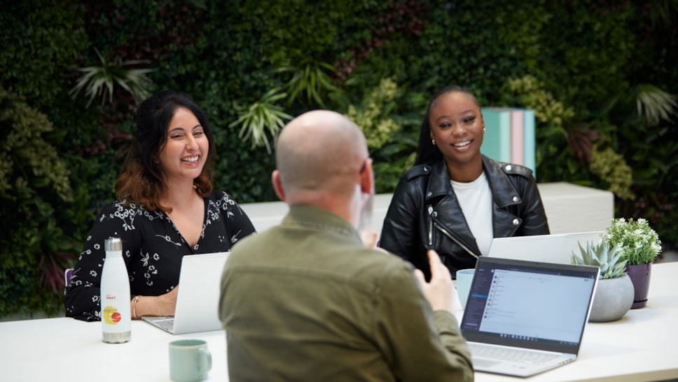 Colleagues at table with green background