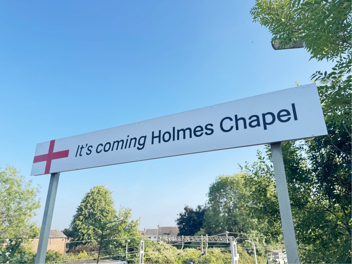 IT'S COMING HOLMES CHAPEL station sign