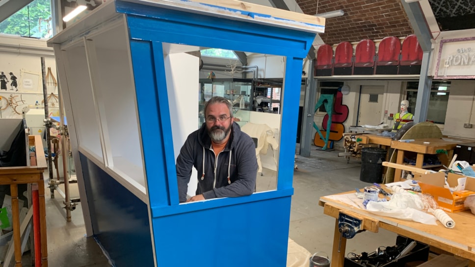 University of Cumbria Ed Cooper stood inside a recreated wooden commentary box in a workshop on campus