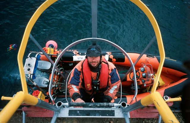 Rothera boatman descends down the ladder at the wharf. Graeme Nott.