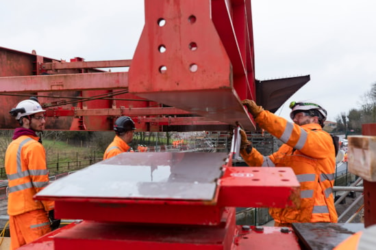 Workers preparing to slide the nose of the Small Dean deck onto temporary bearings