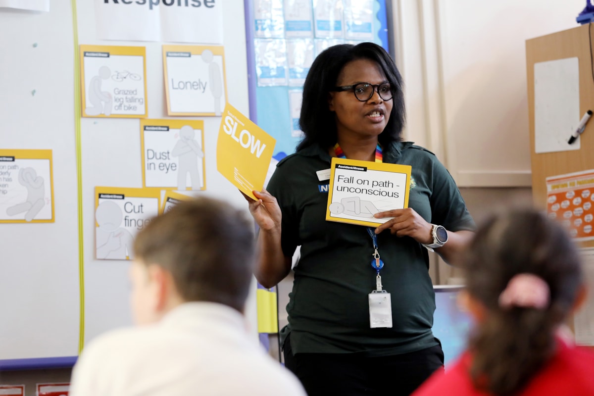 NEAS positive action officer Loveness Scott takes the children through an ambulance response game