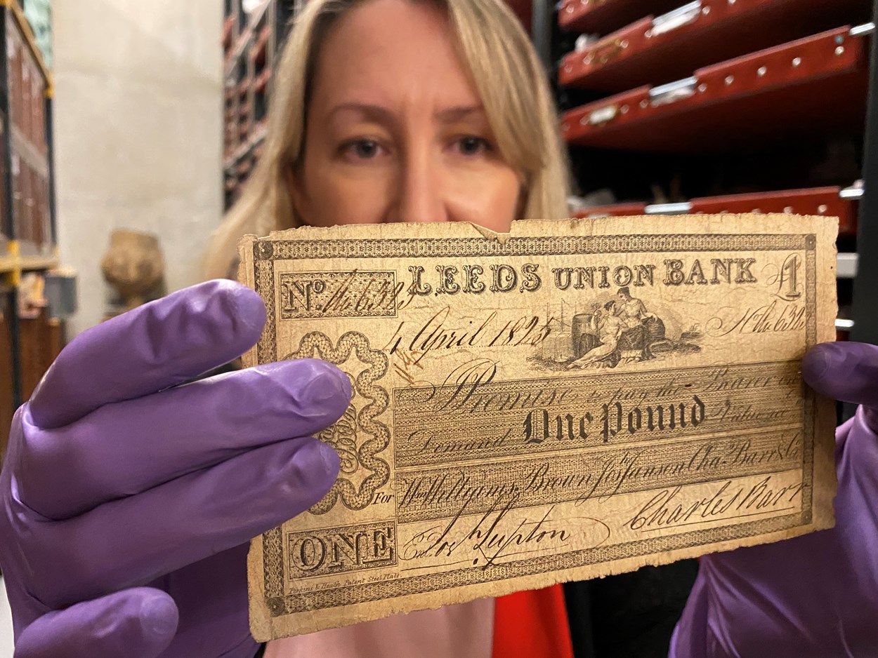 Money Talks: Kat Baxter, Leeds Museums and Galleries’ curator of archaeology and numismatics with one of the local bank notes carrying the branding of both the city itself and now defunct local banking institutions like The Leeds Bank, Leeds Union Bank and Leeds Commercial Bank.