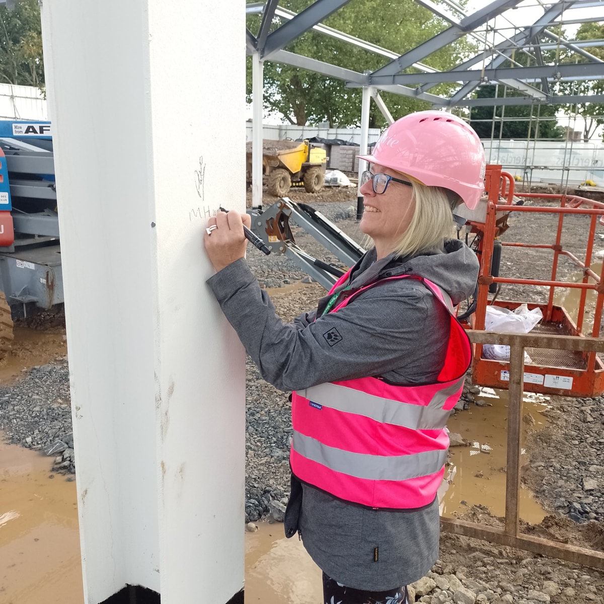 Marie Hunter, headteacher, Pens Meadow Special School signs a girder