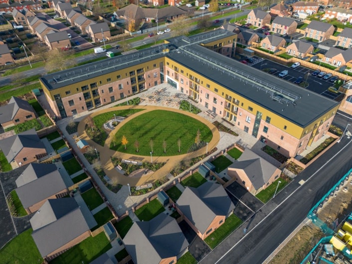 CHGP Middleton: An image (from November 2023) of Gascoigne House, a 60-apartment extra care facility in Middleton delivered through Leeds City Council's Council Housing Growth Programme. Also shown are some of the family homes and wheelchair-accessible bungalows that form part of the wider development.
