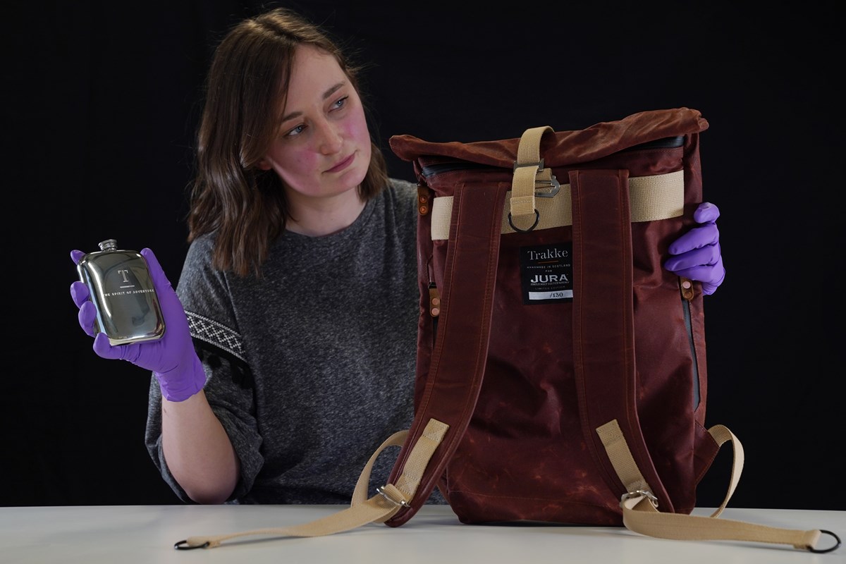 Doctoral Researcher Laura Scobie with a backpack and flask created in with Isle of Jura Distillery and Trakke. Photo © Stewart Attwood.