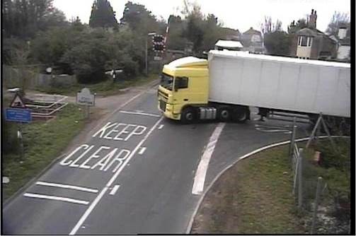Yapton lorry: A lorry, in the background, sits on the level crossing while another pulls out in front of it.