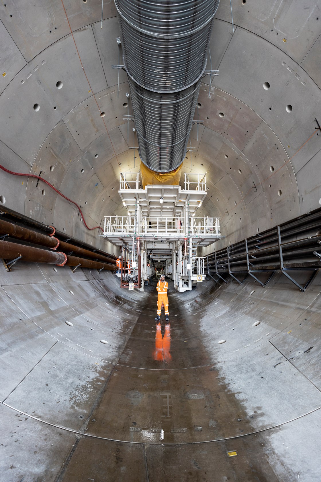 Tunnel Engineer standing inside HS2's Chiltern Tunnel with tunnel boring machine Cecilia in the background, August 2021 HS2-VL-27828