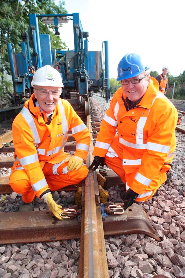FINAL TRACKS LAID ON AIRDRIE-BATHGATE RAIL LINK_2: Hugh Wark, Senior Project Manager (left) and Alan Macmillan, Scheme Sponsor (right) install the final 'golden' pandral clip on the Airdrie-Bathgate line this morning (27 Aug). The 15 miles of new track now link passenger branch lines to Airdrie and Bathgate for the first time in more than fifty years.