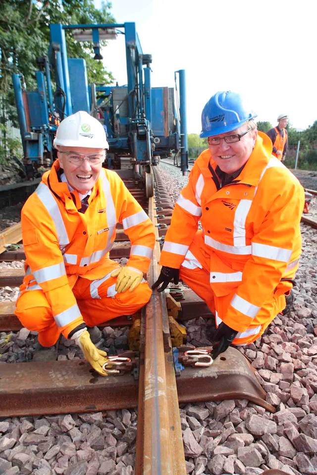 FINAL TRACKS LAID ON AIRDRIE-BATHGATE RAIL LINK_2: Hugh Wark, Senior Project Manager (left) and Alan Macmillan, Scheme Sponsor (right) install the final 'golden' pandral clip on the Airdrie-Bathgate line this morning (27 Aug). The 15 miles of new track now link passenger branch lines to Airdrie and Bathgate for the first time in more than fifty years.