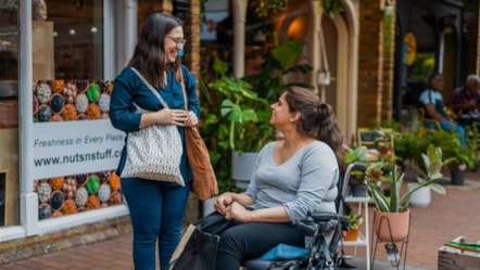 women chatting outside shop