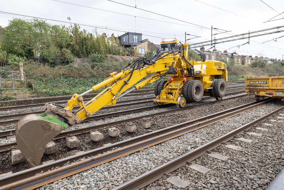 Digger removing old ballast during Willesden track upgrades March 2021