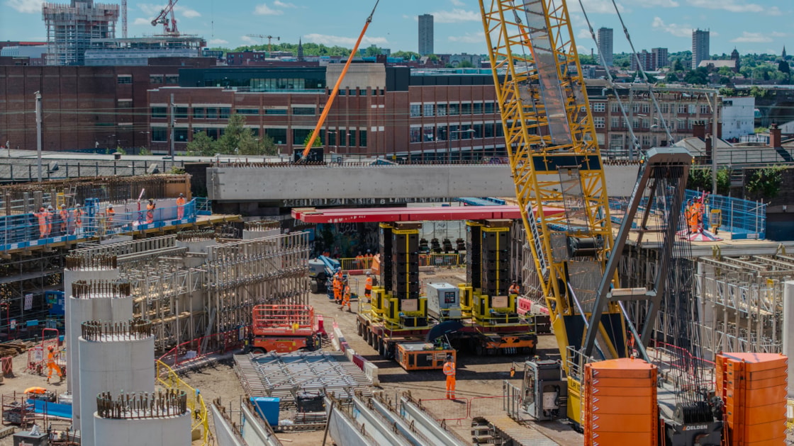Crawler crane being used to lift a U-beam onto an SPMT during teh installation of the first beam June 2026