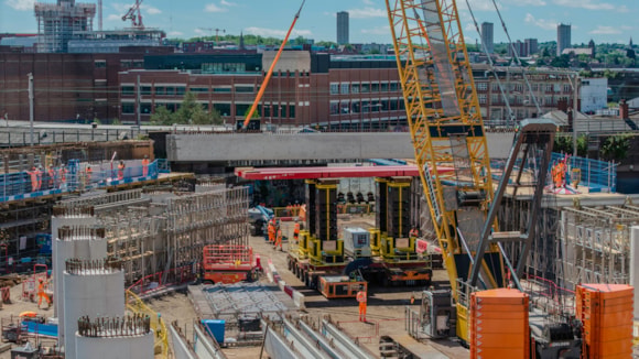 Crawler crane being used to lift a U-beam onto an SPMT during teh installation of the first beam June 2026