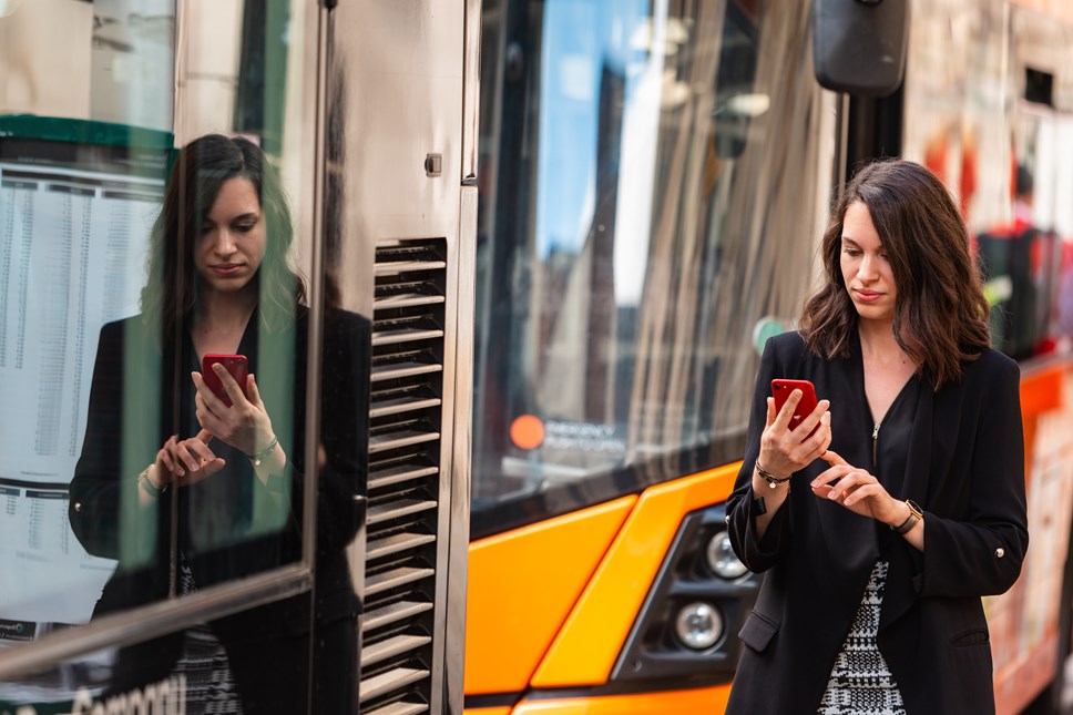 Passenger using phone at bus stop