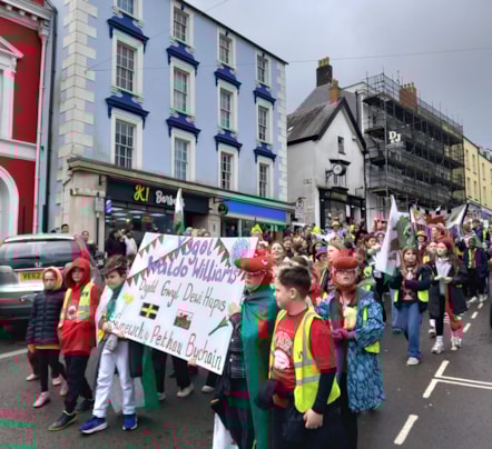 Schools marched down the high street with banners and flags