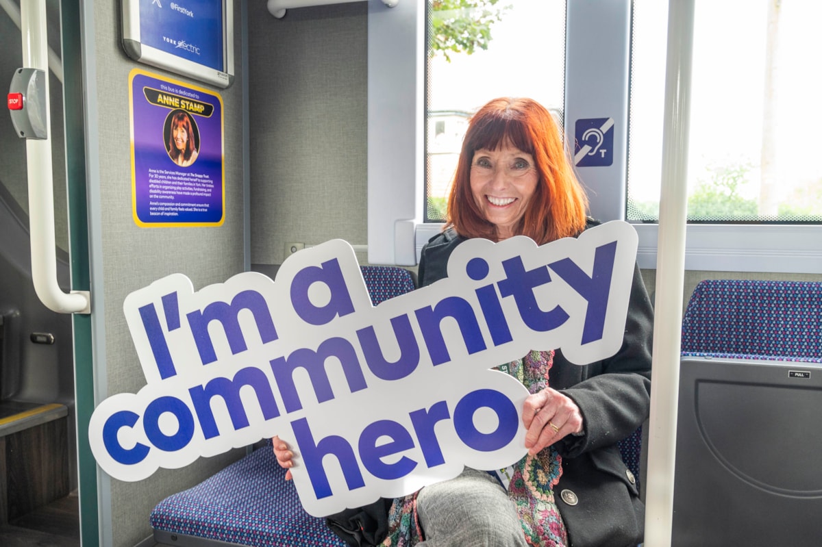 Anne Stamp inside bus with plaque in her name