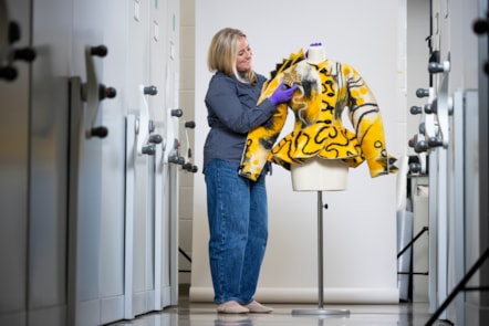 Curator Lisa Mason examines a yellow jacked designed by Jean Muir. Photo © Duncan McGlynn (3)