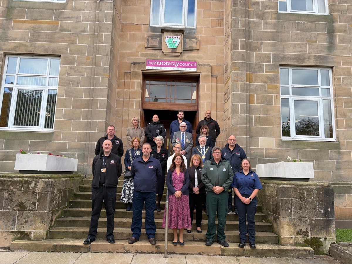 Moray Council Leader, Cllr Kathleen Robertson (centre) with Civic Leader, Cllr John Cowe, second row, are joined by Moray Council Chief Executive, Karen Greaves; Executive Director Economy, Enterprise and Operations, Rhona Gunn; Cllr Peter Bloomfield and members of Moray's emergency services from Po