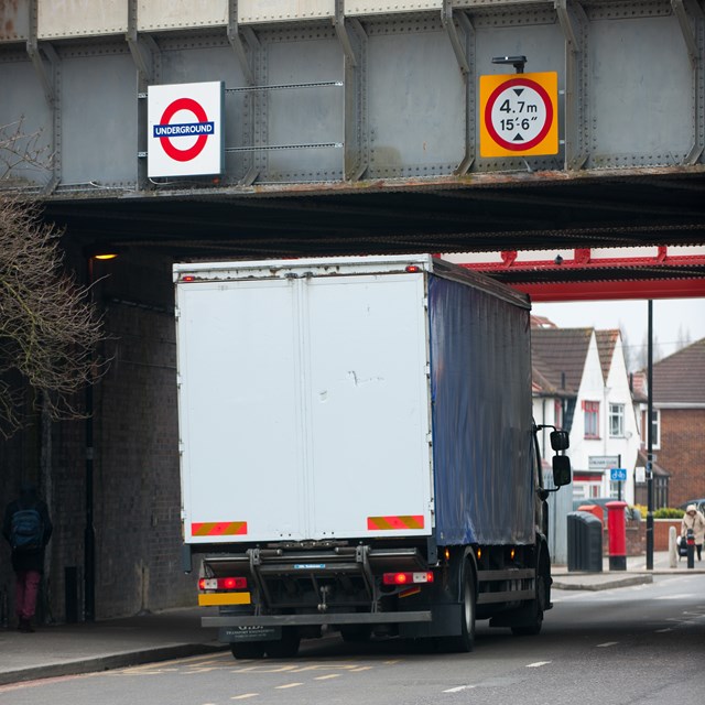 Lorry passing underneath a bridge which carries the London Underground network