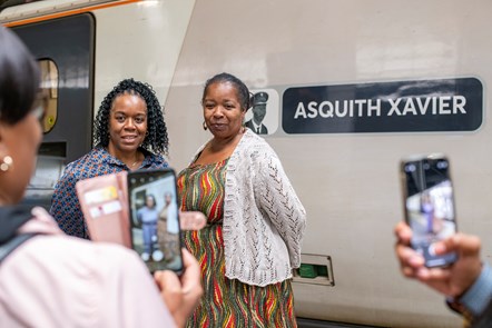 Asquith Xavier's daughters Maria (blue dress) and Sheena with their father's nameplate.