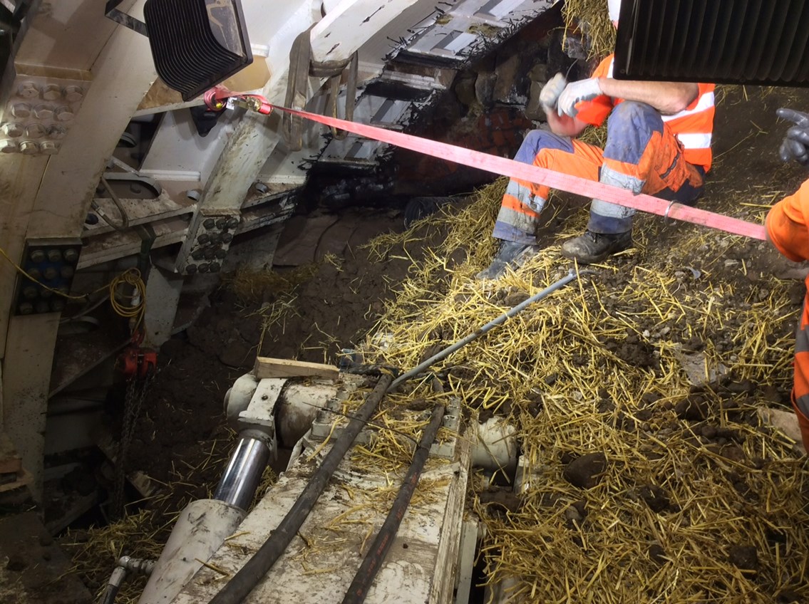 Farnworth Tunnel - engineers on top of material which has poured into the tunnel boring machine