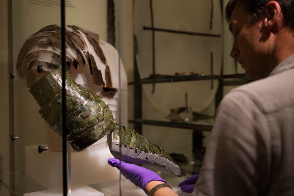 Dr Fraser Hunter installs the Roman arm guard in the Early People gallery at the National Museum of Scoltand. Image copyright Duncan McGlynn (10)