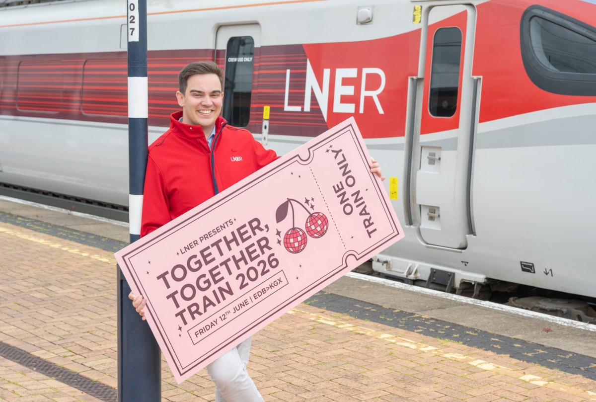 LNER Community Partnerships Manager next to LNER Azuma Train with giant ticket ahead of special Harry Styles-themed train 2