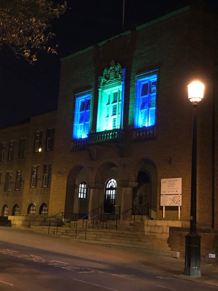 Council house lit in green and blue