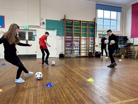 Buckie Thistle midfielder Marcus Goodall watches the footwork of Cluny Primary P7 pupils Ashton Macrae and Maddison Thomas.