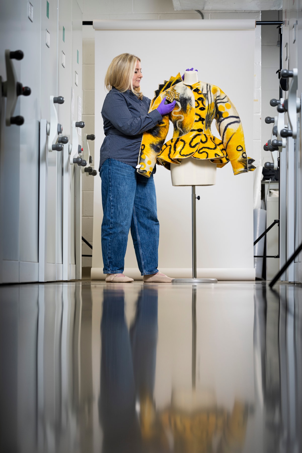 Curator Lisa Mason examines a yellow jacked designed by Jean Muir. Photo © Duncan McGlynn (5)