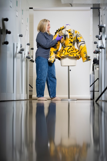 Curator Lisa Mason examines a yellow jacked designed by Jean Muir. Photo © Duncan McGlynn (5)