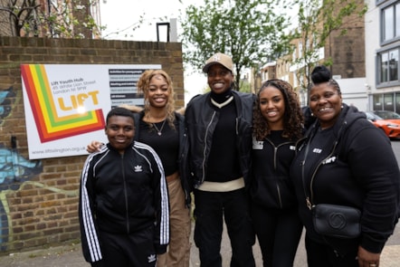 Little Simz, centre, outside Lift youth hub with young people and centre manager Judith Samuel, right