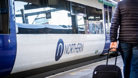 Image shows Northern train at platform with customer on the platform cropped