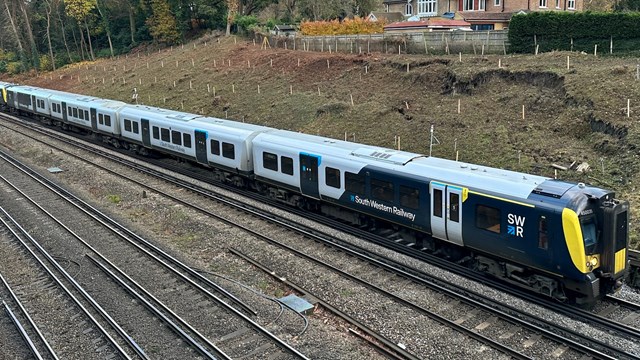 Woking and Crewkerne landslips repairs progress update: An SWR service travels past the landslip site between Brookwood and Woking at 20mph