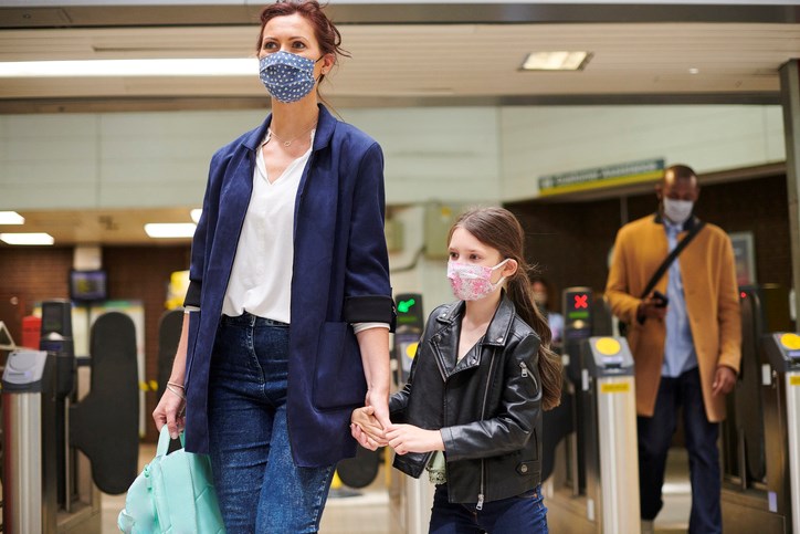 Woman and child at station face coverings